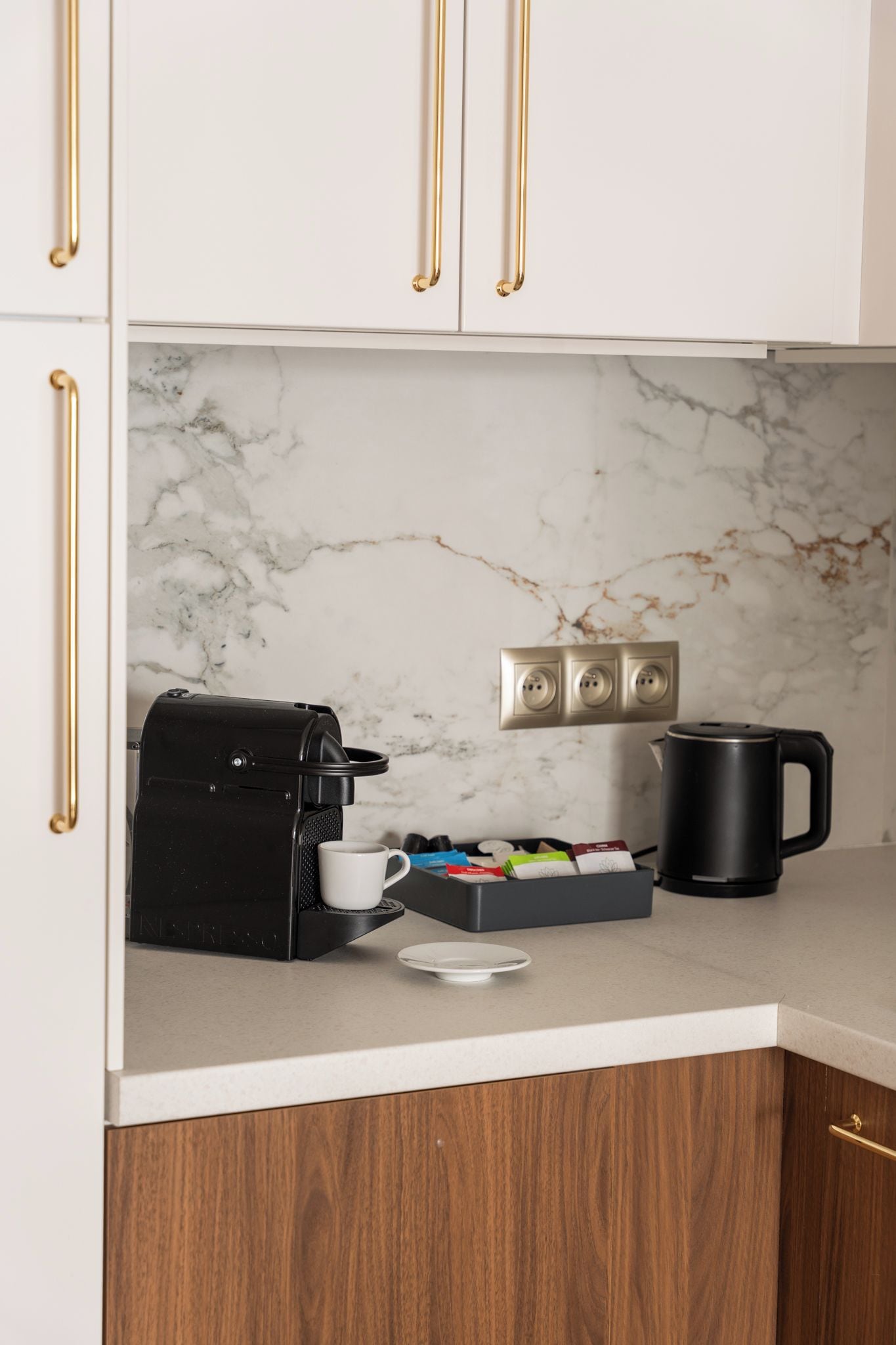 A kitchen with a coffee maker, a mug, and a box of coffee pods on the counter.