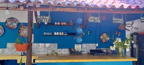 Una cocina con pared azul, encimera de madera y diversos utensilios y adornos.