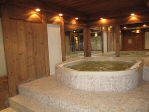 A spa area with a hot tub, wooden walls, and tiled flooring. - 50m from ski slopes, sauna, hammam, balcony, fireplace or stove, tv, ski locker, 73m², La Plagne (La Plagne)