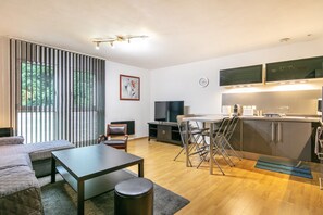 Ein modernes Wohnzimmer mit einer Couch, einem Esstisch und einem Fernseher.