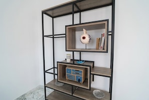 A modern, multi-tiered wooden shelving unit with a geometric design, featuring a decorative ceramic piece and books on the top shelf. - sandra 19 (Gammarth)