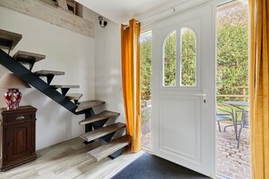 A staircase with wooden steps and black metal supports leading to a white door with a window. - Le Gite du Grand Parc - Jardin et parking privé (L'Oudon)