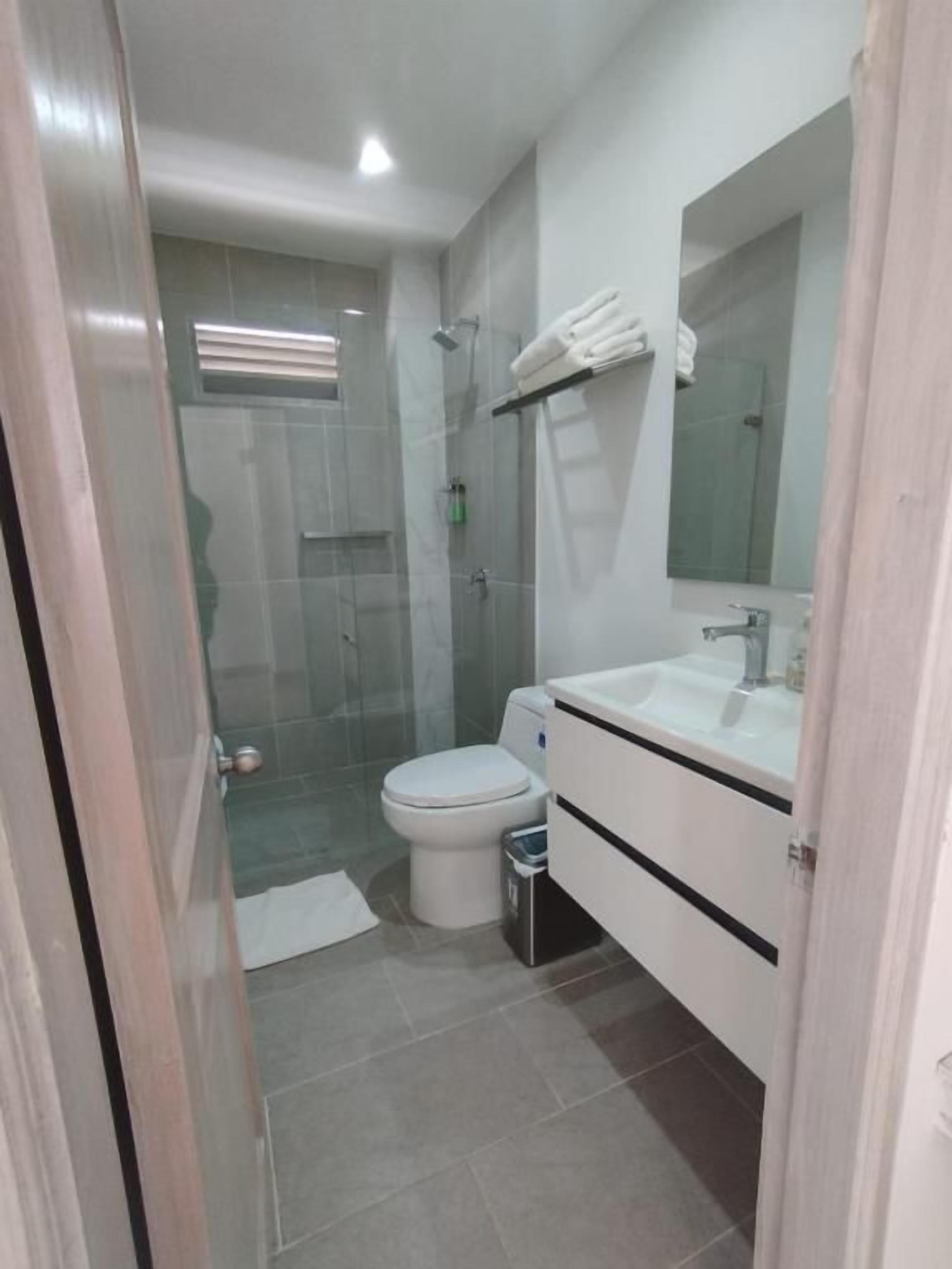 Une salle de bain avec des toilettes, un lavabo et une douche.