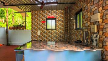 A kitchen area with a stone wall, a window, and a ceiling fan.