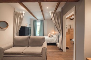 A bedroom with a bed, a chair, a wardrobe, and a mirror. - Limoilou | 3 Bedrooms | Terrace | The 703 (Québec City)