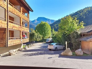 A wooden building with balconies, a parking area, and a mountain view. - Enchaple S58 - 4 peoples (Saint-Jean-d´Aulps)