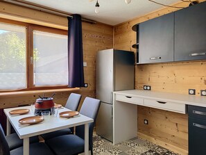 A compact kitchen with a dining table, chairs, and a refrigerator. - Enchaple S58 - 4 peoples (Saint-Jean-d´Aulps)