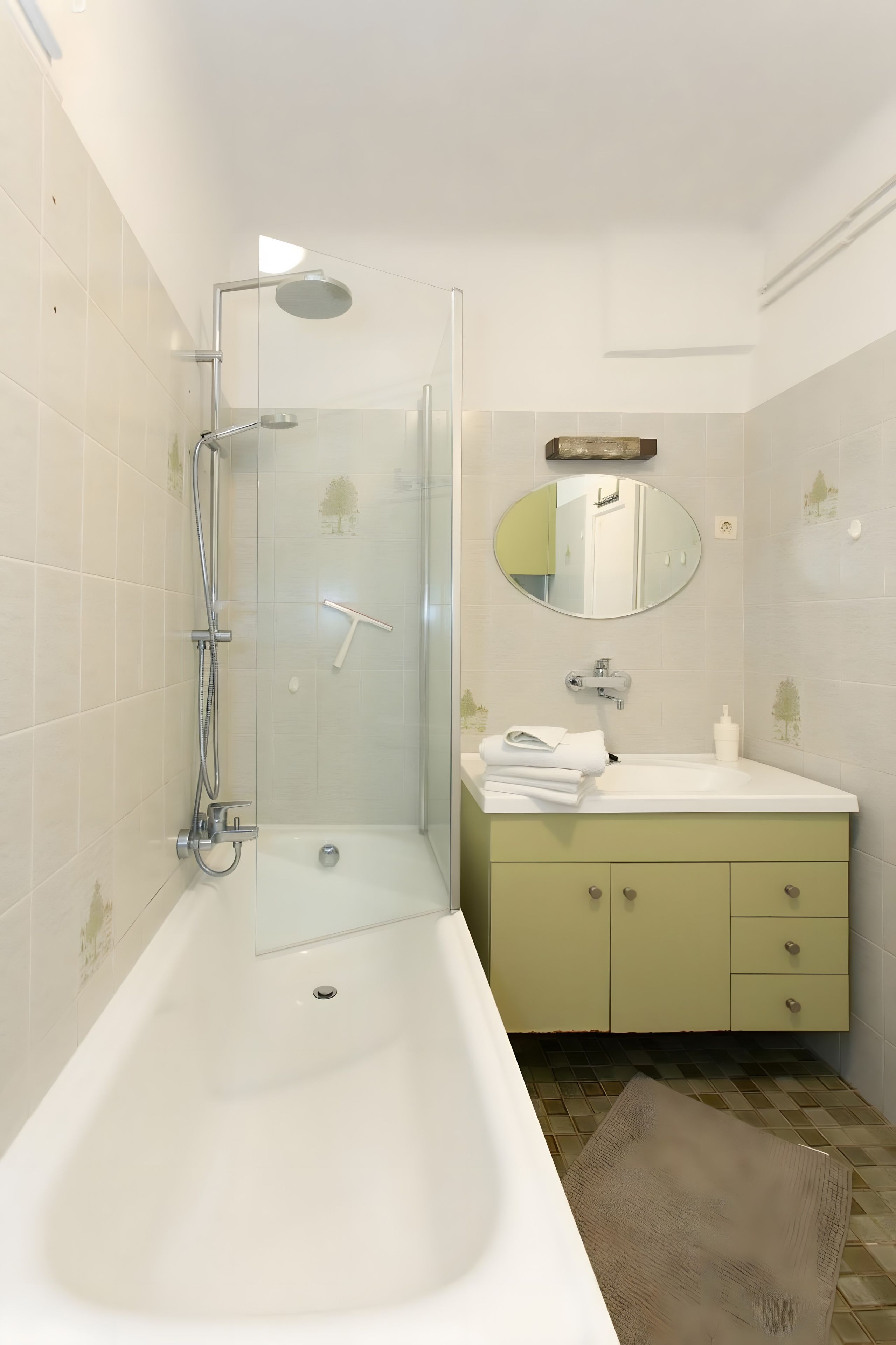 A modern bathroom with a glass-enclosed shower, a white sink, and a mirror above it.