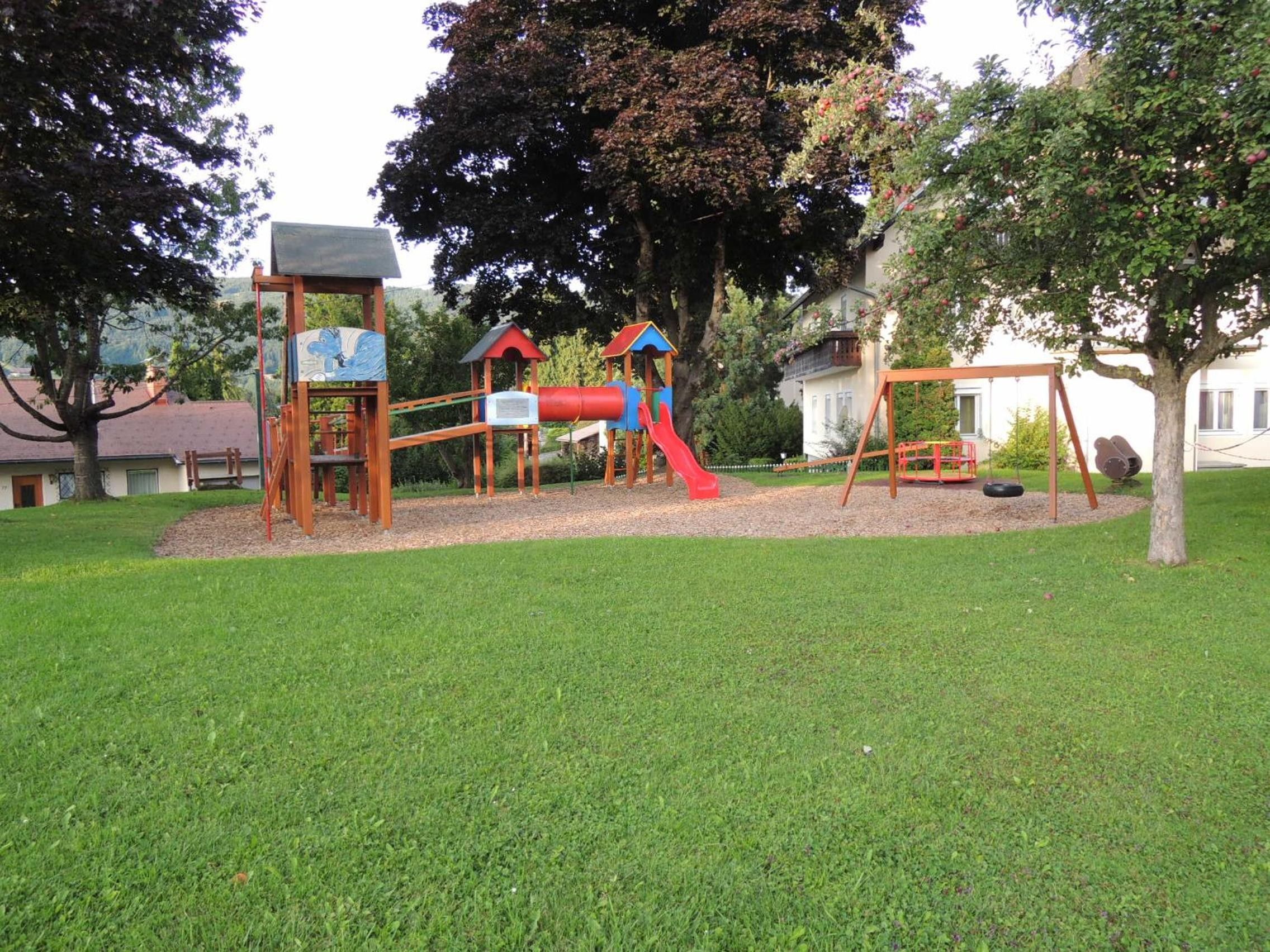 A playground with a slide, climbing structures, and a swing set.