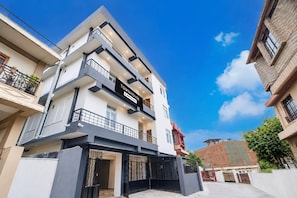 A multi-story residential building with a prominent 'TOWNHOUSE' sign, balconies, and a gated entrance. - Classic The Polo Continental (Shillong)