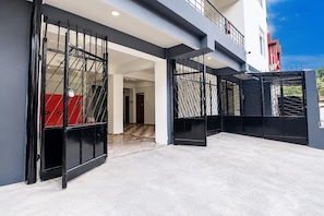 A modern building with a covered outdoor area, a red structure, and a staircase. - Classic The Polo Continental (Shillong)