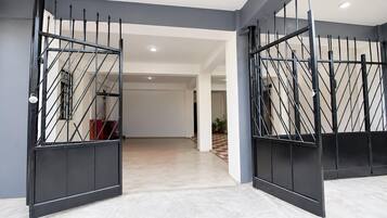 Ein großzügiger Innenraum mit modernem Design, der ein weitläufiges, offenes Treibhaus mit Schachbrettmuster und einer sichtbaren Treppe in eine andere Ebene zeigt.