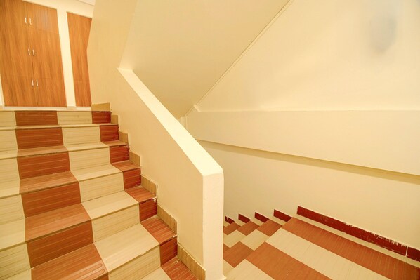 A staircase with alternating beige and brown steps, leading to a landing with a wooden door.
