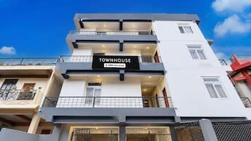 A multi-story building with a sign indicating it is serviced by OYO.
