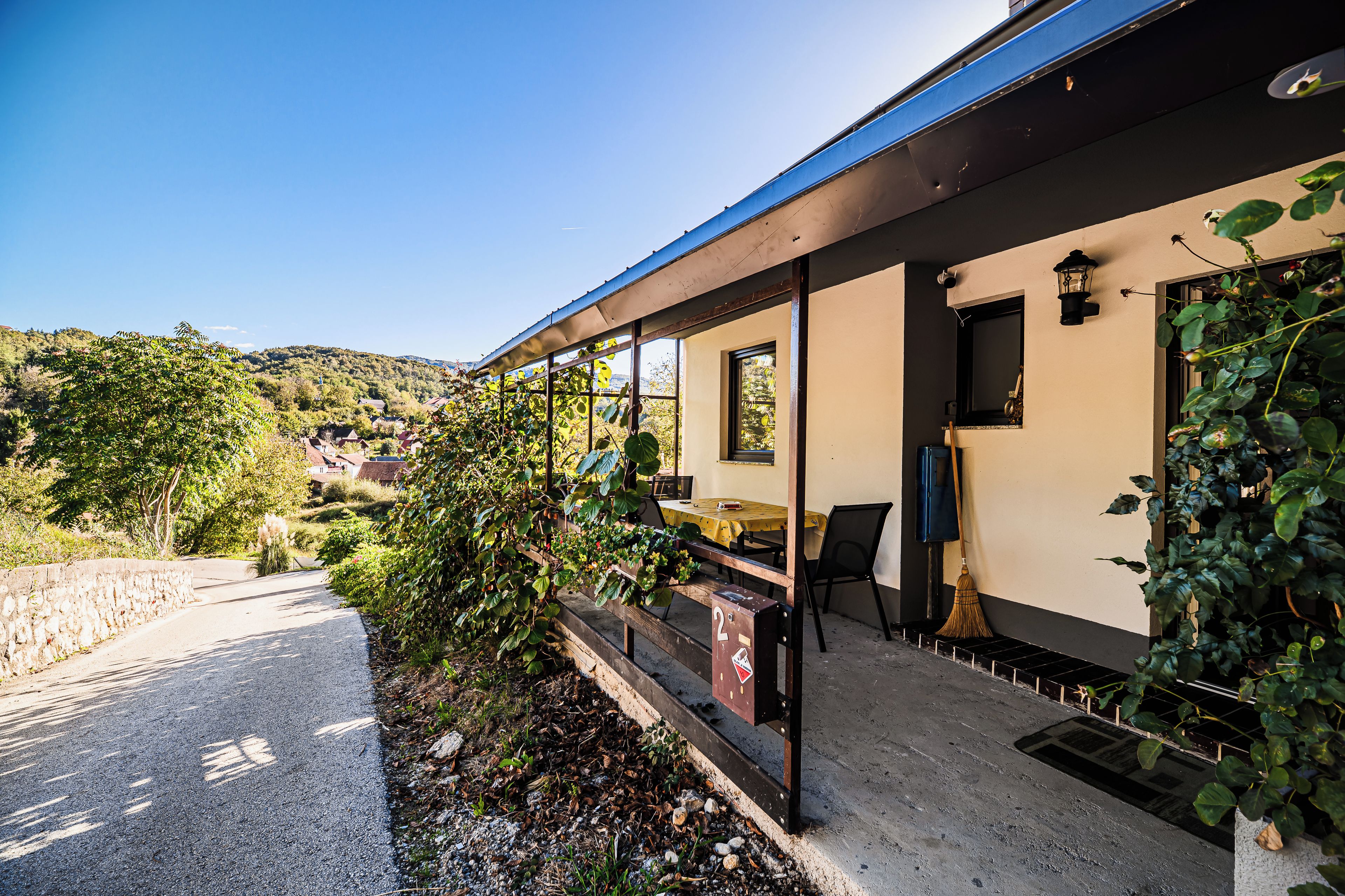 A building with a covered outdoor seating area, a window, and a door.
