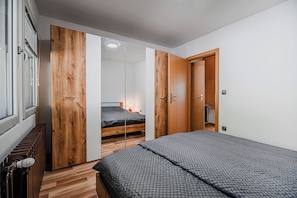 A bedroom with a bed, a wardrobe, and a radiator. - 3 Bedroom Apartment TI&JAZ (Brežice)
