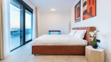Een hotelkamer met een bed, een nachtkastje, een potplant en kunst aan de muur.