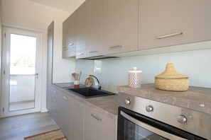 Une cuisine moderne équipée d’un four encastré, d’un évier et d’une cuisinière.