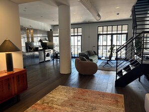 Ein modernes Interieur mit Küche, Wohnbereich und Treppe.