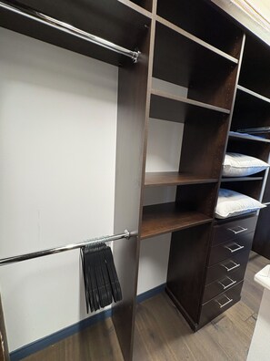 Ein begehbarer Kleiderschrank mit mehreren Regalen, Schubladen und einer Kleiderstange.