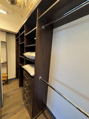 A walk-in closet with open shelving, a padded bench, and a sliding door. - Penthouse Loft in the Grand historic Broadway Hollywood (Los Angeles)