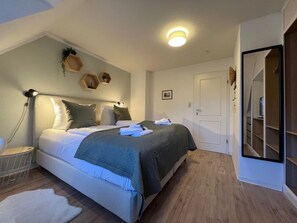 A bedroom with a bed, bedside lamp, and a nightstand. - House Strandherz, Part Port (Utersum)