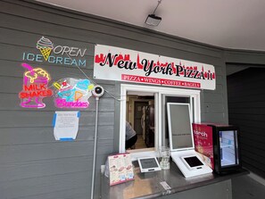A New York Pizza II storefront with neon signs for ice cream, milkshakes, and sundae. - Direct Oceanfront! Charming condo in Myrtle Beach perfect for your getaway! (Myrtle Beach)
