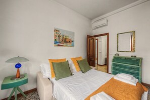 Een hotelkamer met een bed, een schilderij, een dressoir en een lamp.