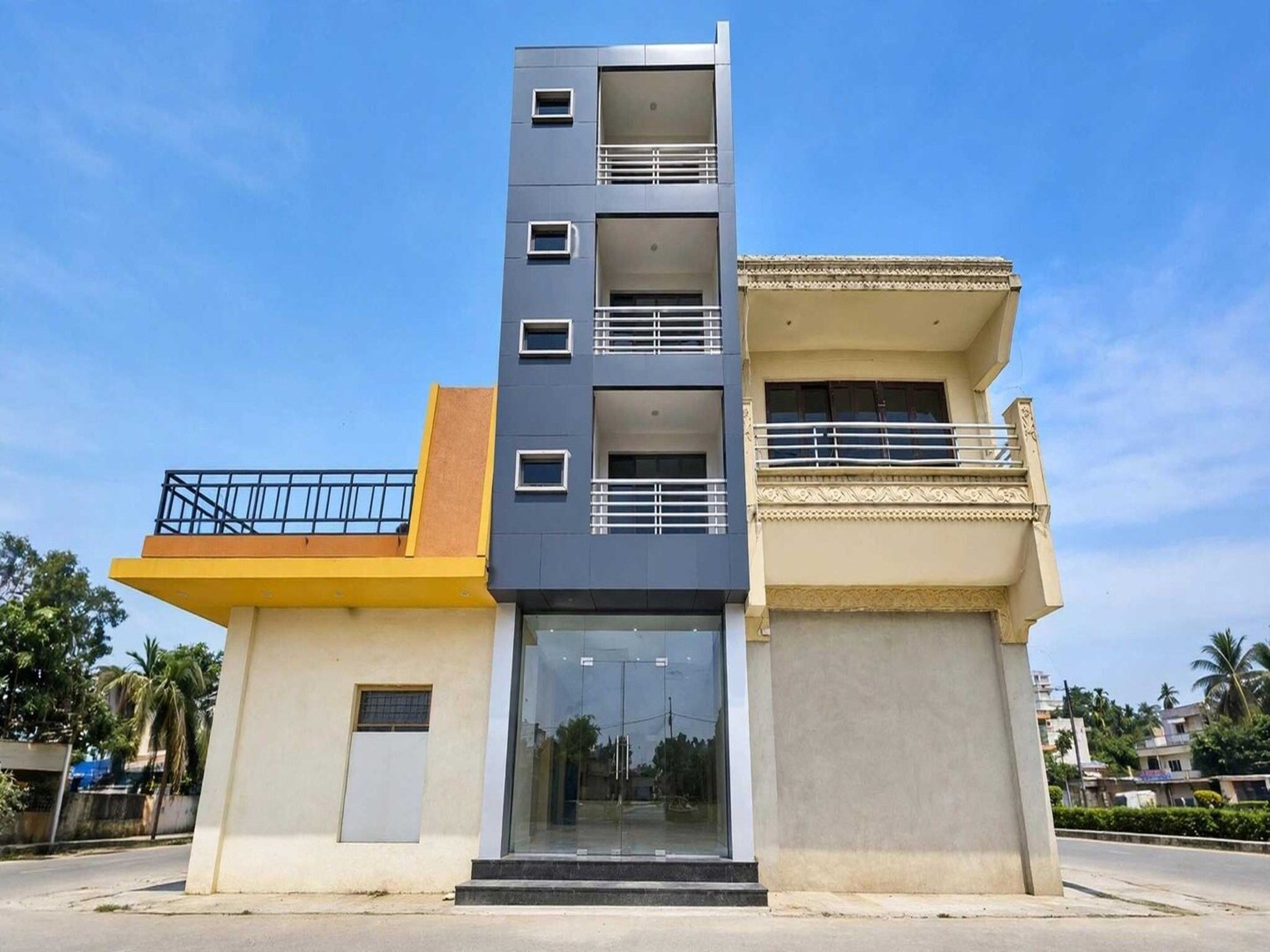 A multi-story building with a modern design, featuring a glass entrance and balconies.