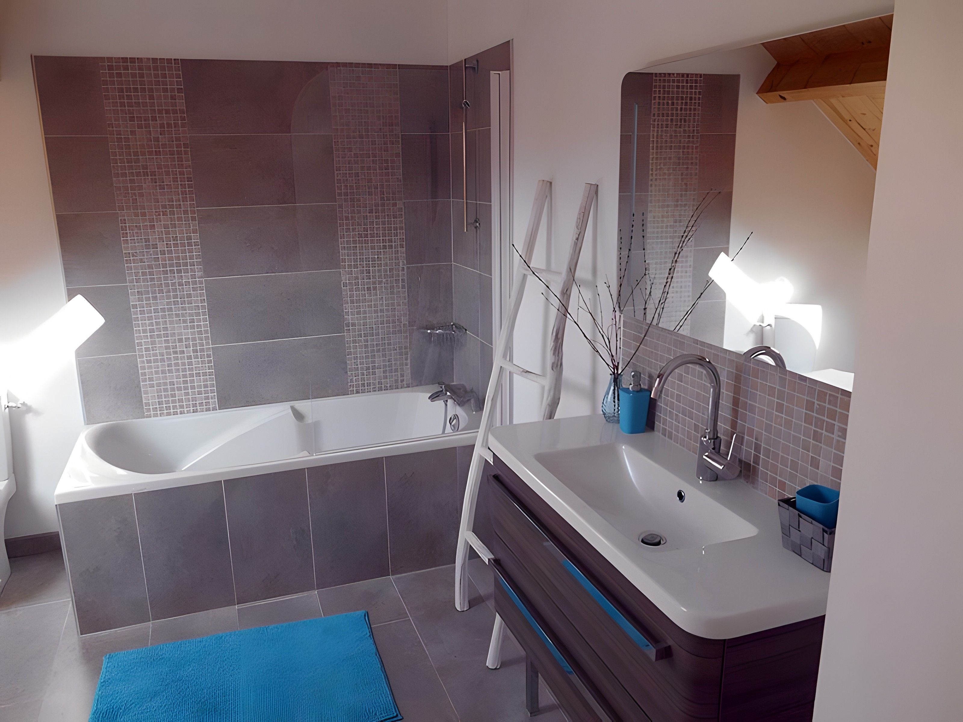 Een moderne badkamer met een ruime badkuip, een wastafel met spiegel en een douchehoek.