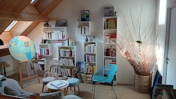 Eine gemütliche Leseecke mit Bücherregalen, einem Globus und einer bequemen Sitzgruppe.