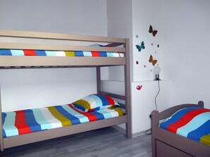 A bunk bed with striped bedding and a wall-mounted lamp. - Guest Rooms 'La Maison Des Étangs - Le Nid' with Lake View, Wi-Fi and Air Conditioning (Vinon)