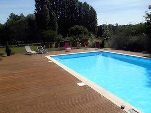 A rectangular swimming pool with a wooden deck and lounge chairs. - Guest Rooms 'La Maison Des Étangs - Le Nid' with Lake View, Wi-Fi and Air Conditioning (Vinon)