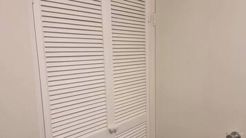 A white closet with horizontal louvered doors and a silver doorknob.