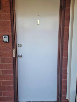 A white door with the number 1, a doorbell, and a mailbox on the brick wall. - Entire 3 bedroom unit- 5 min to CBD, Hannan street (Piccadilly)