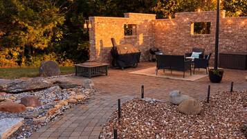 A patio area with a brick wall, outdoor furniture, and string lights.