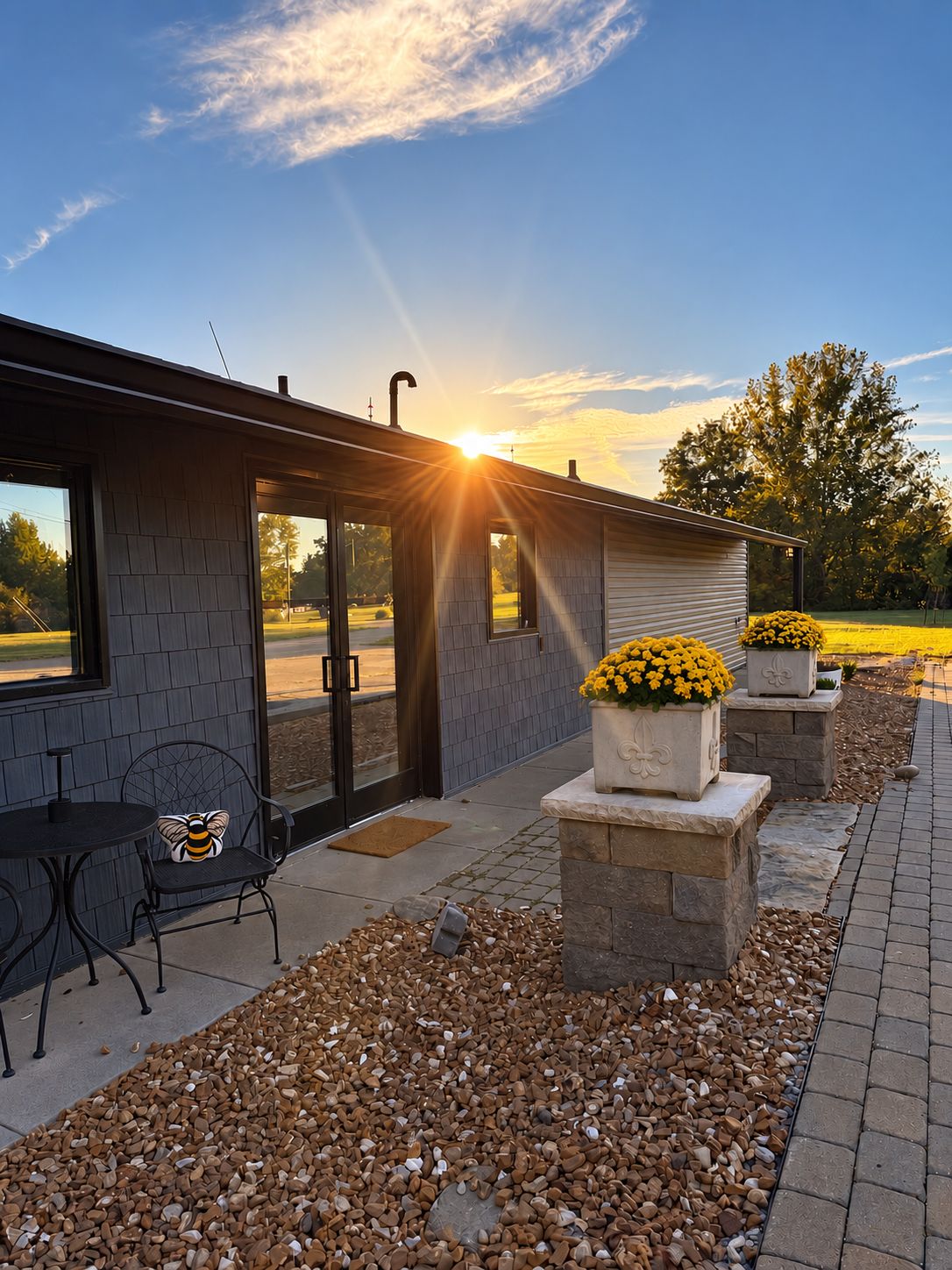 A modern building with a patio area featuring a seating arrangement and flower planters.