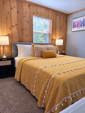 A bedroom with a bed, two bedside tables, a window with blinds, and a wall-mounted artwork. - Entire Home in Mount Eden, KY (Mount Eden)