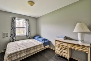 A bedroom with a bed, a dresser, a lamp, and a window with curtains. - Large 11 BR, Hot tub, Arcades 5 Min Hunter MT (Tannersville)