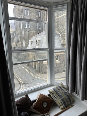 A room with a large window overlooking a street and buildings. - The Pier Hotel (Aberystwyth)