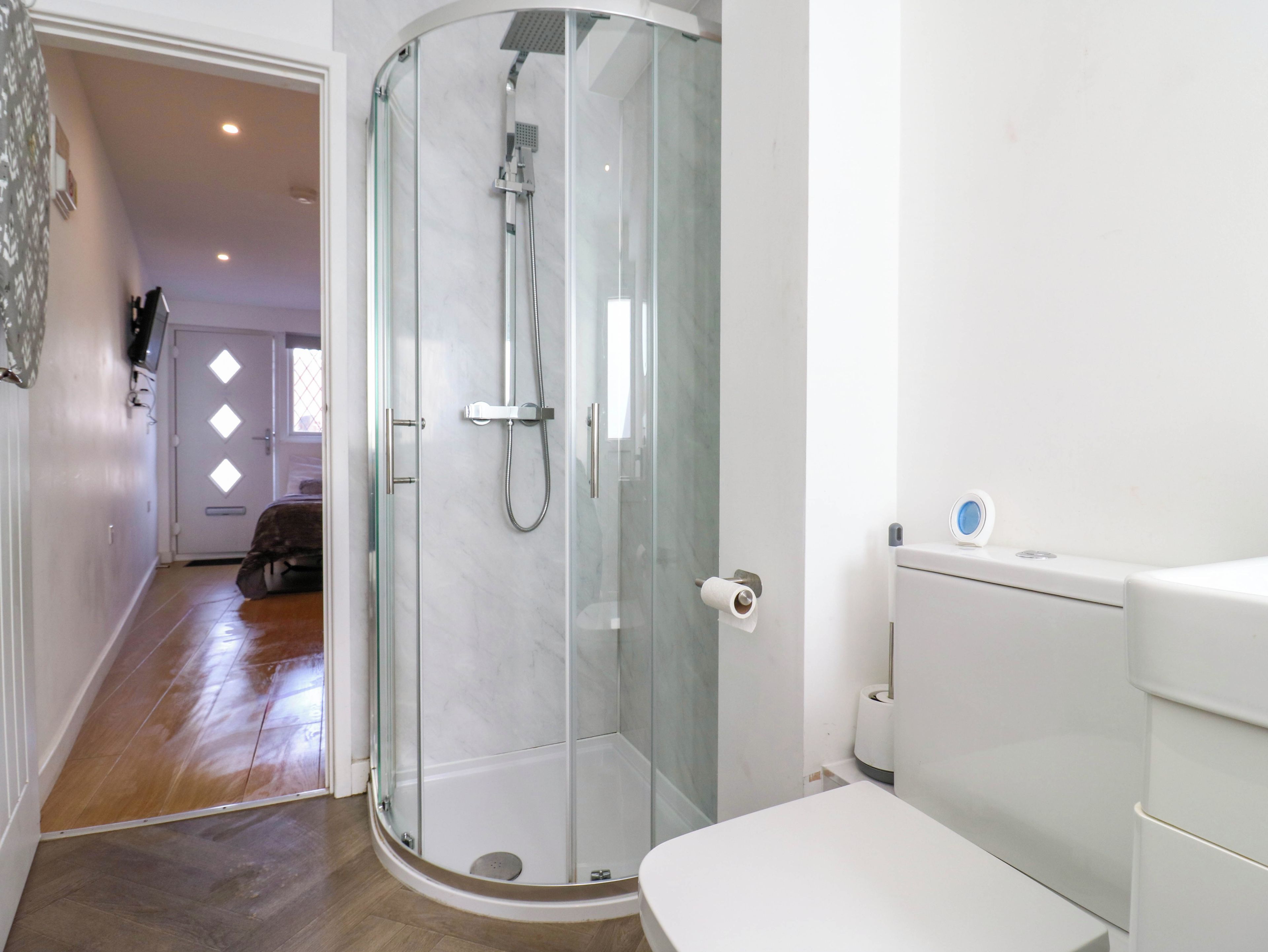 A modern bathroom with a glass-enclosed shower, a toilet, and a bidet.