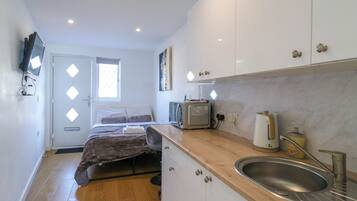 A compact kitchen with a sink, a toaster, and a window.