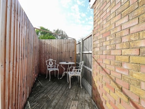 A wooden deck with two white metal chairs and a small table. - Annex (Southend-on-Sea)