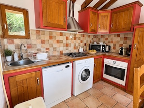A compact kitchen with a dishwasher, washing machine, microwave, and oven. - Bergerie Babella (Olmeto)