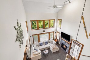 A spacious living room with a fireplace, a sofa set, and a television. - Boyne Mountain Ski/In-Out Condo W/Hot tub Sleeps 12 (Boyne Falls)