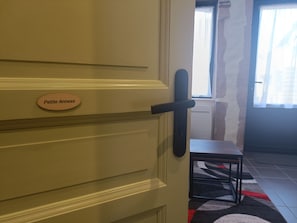 Una porta con una targa che riporta la scritta 'Petite Annexe' e un maniglia nera.