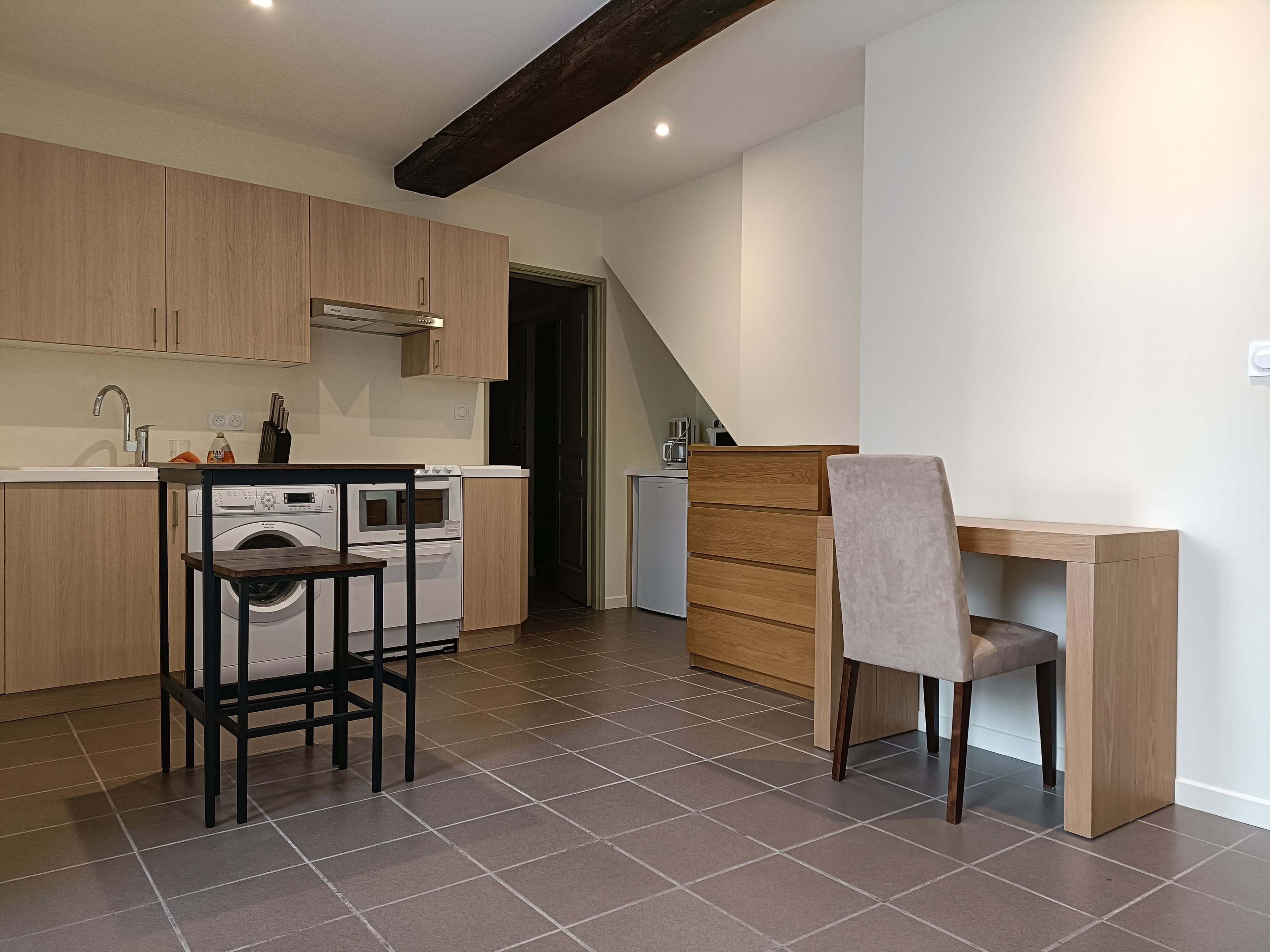 Een moderne keuken met houten kastjes, een inbouwoven en een wasmachine.