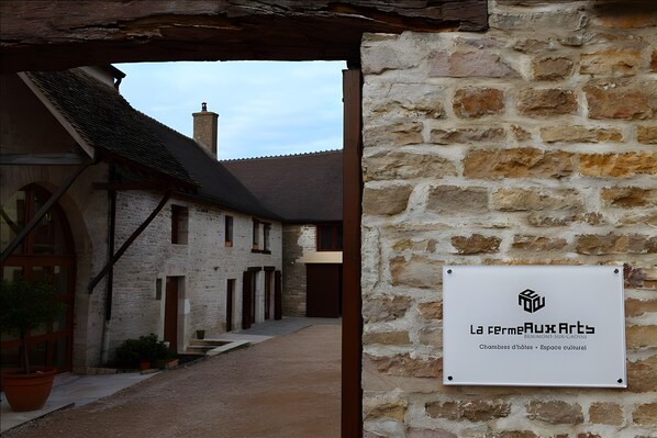 A stone building with a sign that reads 'La Fermeaux Arts.'