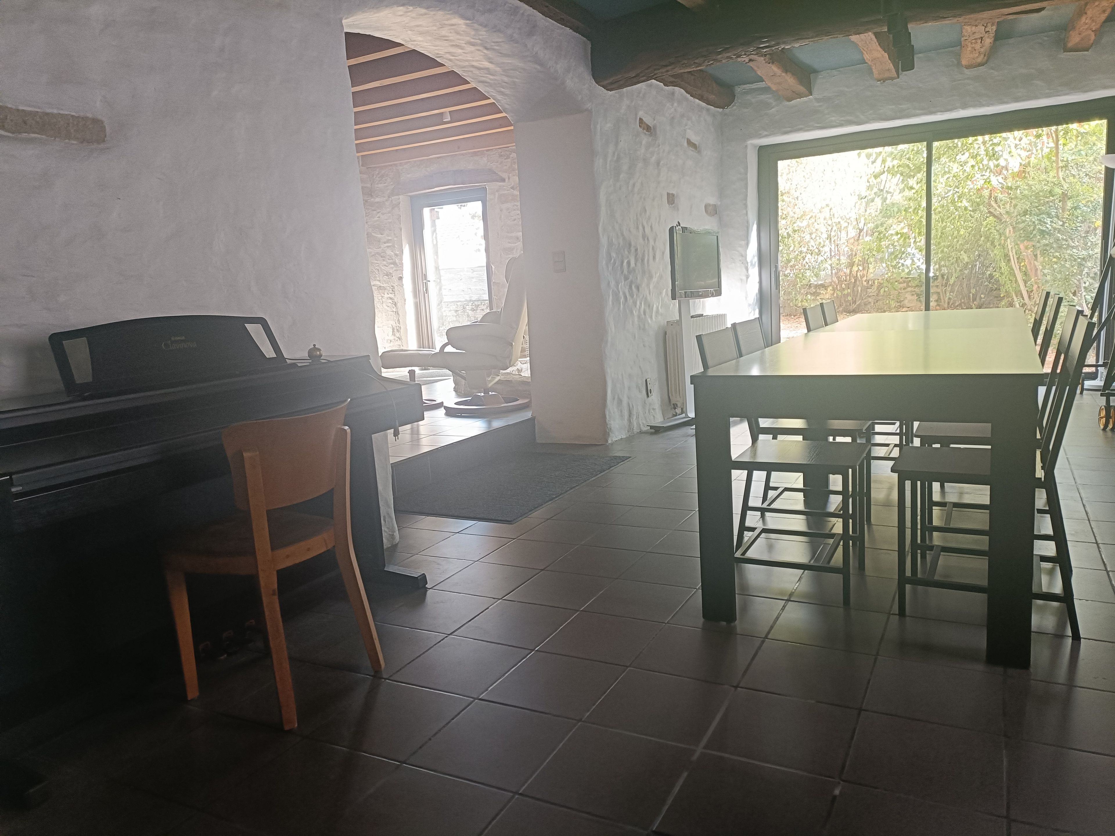 Ein Essbereich mit Klavier, Tisch und Stühlen.