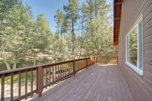 A wooden deck with a railing, overlooking a forested area with tall trees. - Cozy Prescott Cabin, Surrounded By Ponderosa Pines (Prescott)